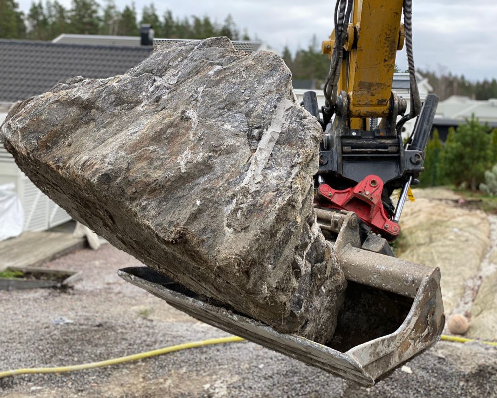 Sten i en grävskopa