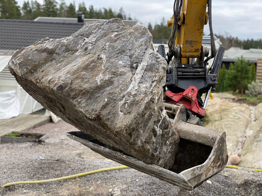 Sten i en grävskopa