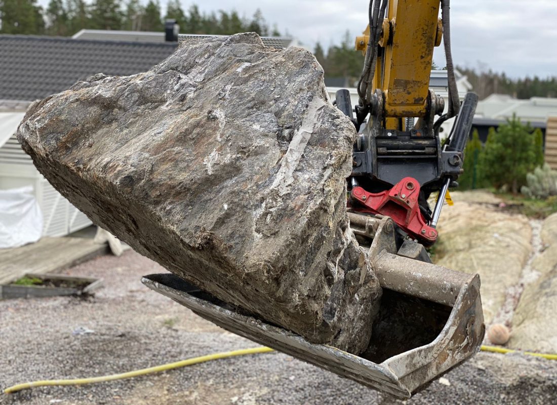 Sten i en grävskopa
