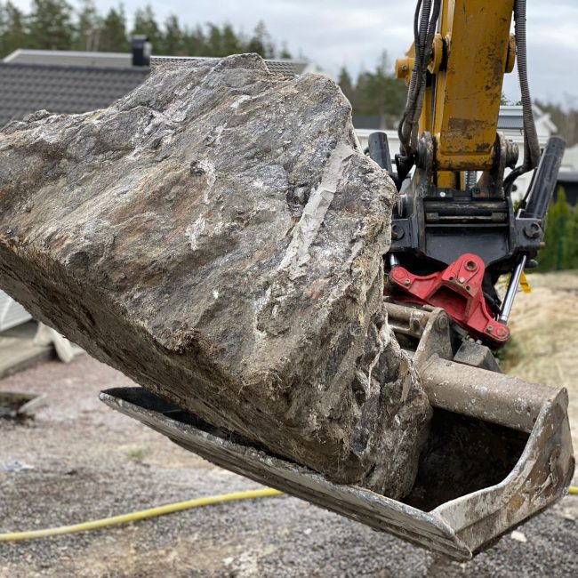 Sten i en grävskopa